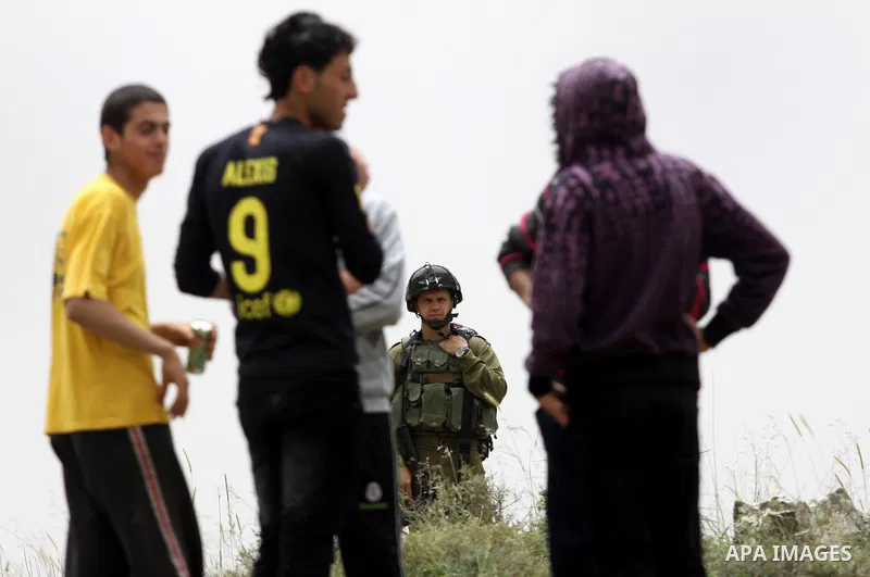 Israeli soldiers stand between Palestinian farmers and jewish settlers after clashes in Qusra village near the west bank city of Nablus, on April 29, 2012. Photo by Nedal Shtieh