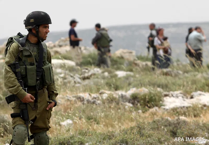 Israeli soldiers stand between Palestinian farmers and jewish settlers after clashes in Qusra village near the west bank city of Nablus, on April 29, 2012. Photo by Nedal Shtieh