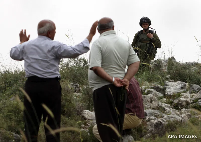 Israeli soldiers stand between Palestinian farmers and jewish settlers after clashes in Qusra village near the west bank city of Nablus, on April 29, 2012. Photo by Nedal Shtieh