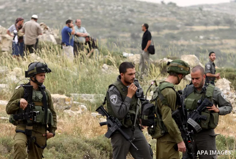 Israeli soldiers stand between Palestinian farmers and jewish settlers after clashes in Qusra village near the west bank city of Nablus, on April 29, 2012. Photo by Nedal Shtieh