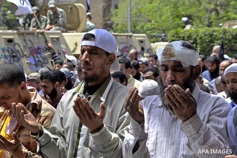 Followers of Egyptian Muslim cleric and former candidate for the Egyptian presidency Hazem Abu Ismail, including a man injured in overnight clashes, pray outside the ministry of Defense in Cairo, Egypt, Sunday, April 29,...
