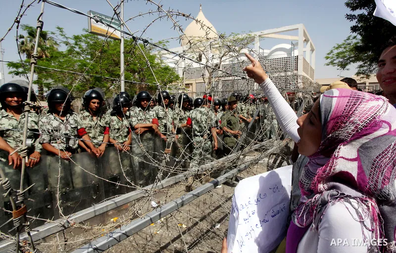 Egyptian protesters march back to the Ministry of Defense after battling thugs in the nearby streets of the Abasseya neighborhood of Cairo for several hours on Sunday, April 29, 2012. The army had mover back their securi...