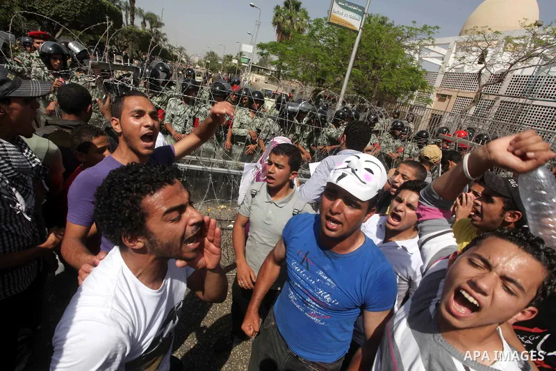 Egyptian protesters march back to the Ministry of Defense after battling thugs in the nearby streets of the Abasseya neighborhood of Cairo for several hours on Sunday, April 29, 2012. The army had mover back their securi...