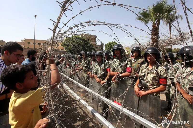 Egyptian protesters march back to the Ministry of Defense after battling thugs in the nearby streets of the Abasseya neighborhood of Cairo for several hours on Sunday, April 29, 2012. The army had mover back their securi...