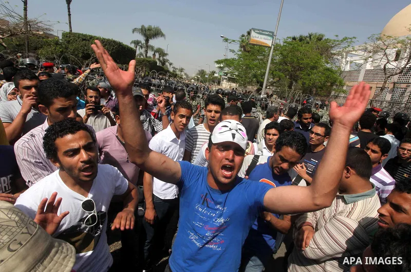 Egyptian protesters march back to the Ministry of Defense after battling thugs in the nearby streets of the Abasseya neighborhood of Cairo for several hours on Sunday, April 29, 2012. The army had mover back their securi...