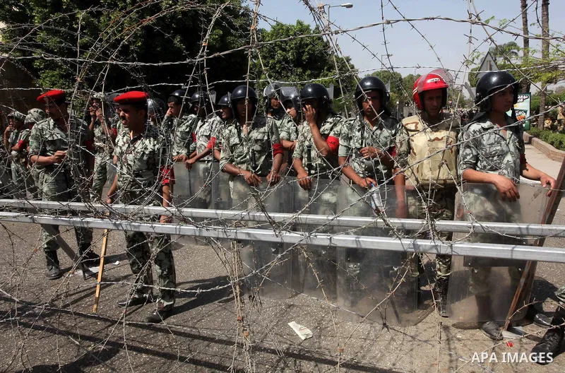 Egyptian protesters march back to the Ministry of Defense after battling thugs in the nearby streets of the Abasseya neighborhood of Cairo for several hours on Sunday, April 29, 2012. The army had mover back their securi...