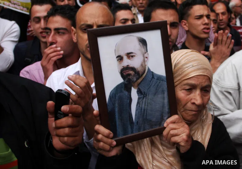 Palestinian protesters hold up banners and portraits of a prisoners jailed in Israel,during a rally in solidarity with prisoners in Israeli jails, in the West Bank city of Ramallah, April 29, 2012.Over the past week, ove...