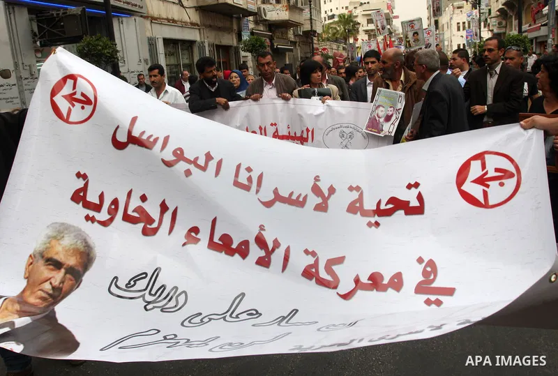 Palestinian protesters hold up banners and portraits of a prisoners jailed in Israel,during a rally in solidarity with prisoners in Israeli jails, in the West Bank city of Ramallah, April 29, 2012.Over the past week, ove...