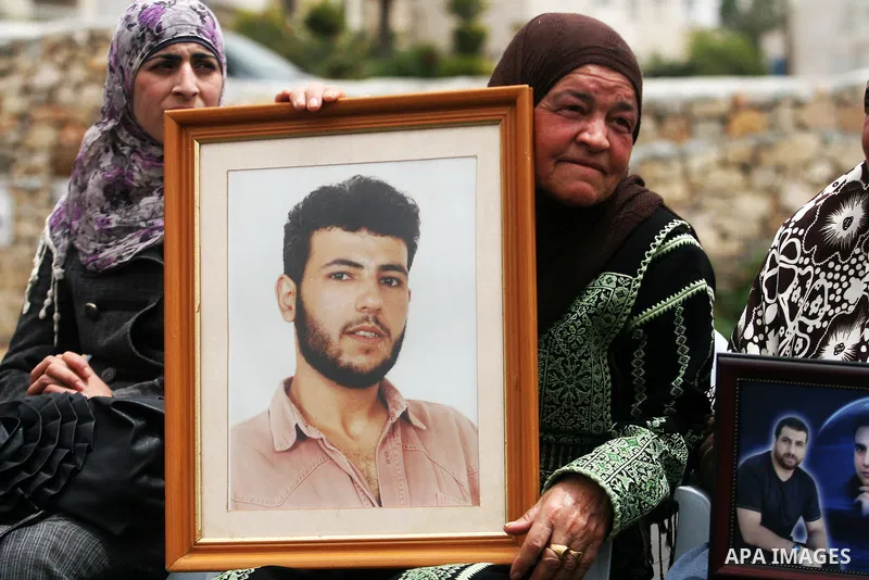 Palestinian protesters hold up banners and portraits of a prisoners jailed in Israel,during a rally in solidarity with prisoners in Israeli jails, in the West Bank city of Ramallah, April 29, 2012.Over the past week, ove...