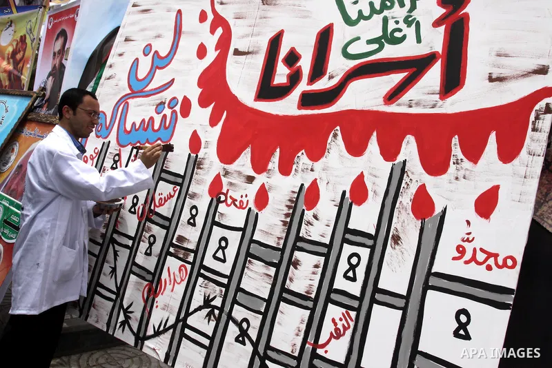 Palestinian artist draw graffiti during Sit-in tent to show solidarity with Palestinians prisoners held in Israeli jails in Gaza City on April 30, 2012. At least 1,350 Palestinian prisoners being held in Israel are obser...