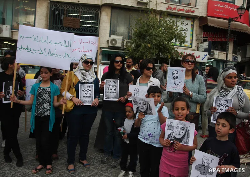 Palestinian journalists hold up banners and portraits of a prisoners jailed in Israel,during a rally in solidarity with prisoners in Israeli jails, in the West Bank city of Ramallah, April 29, 2012.Over the past week, ov...