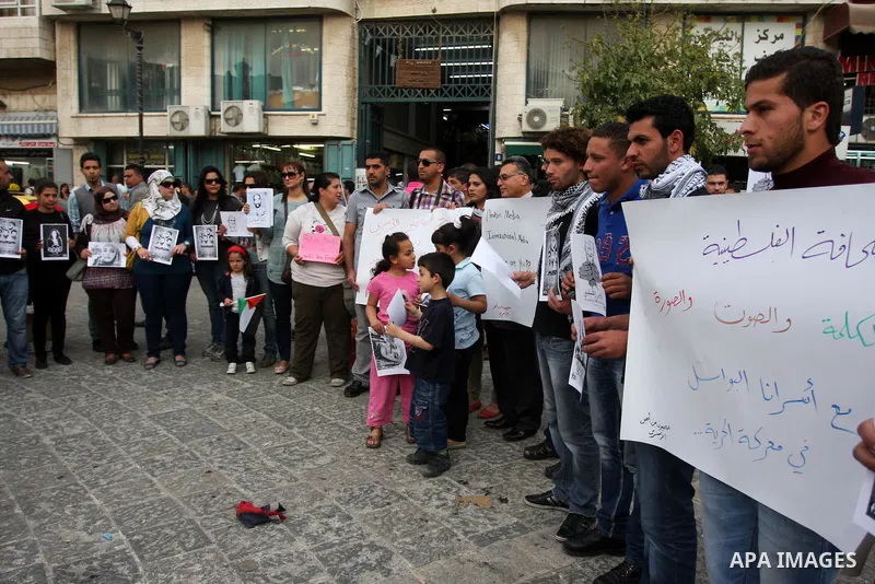Palestinian journalists hold up banners and portraits of a prisoners jailed in Israel,during a rally in solidarity with prisoners in Israeli jails, in the West Bank city of Ramallah, April 29, 2012.Over the past week, ov...