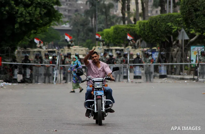 Egyptian Protester Riding a motorcycle, in front of Egyptian military police standing guard near the Ministry of Defense in the Abbassiya district of Cairo April 30, 2012. Protesters continued their sit-in on April 30 af...