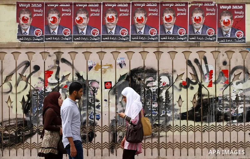 Egyptian Protesters walk near the Ministry of Defense in the Abbassiya district of Cairo April 30, 2012. Protesters continued their sit-in on April 30 after they were attacked two days earlier, which resulted in the deat...