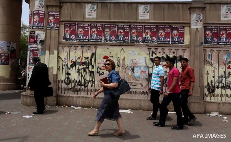Egyptian Protesters walk near the Ministry of Defense in the Abbassiya district of Cairo April 30, 2012. Protesters continued their sit-in on April 30 after they were attacked two days earlier, which resulted in the deat...