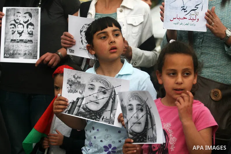 Palestinian children hold up banners and portraits of a prisoners jailed in Israel,during a rally in solidarity with prisoners in Israeli jails, in the West Bank city of Ramallah, April 30, 2012. Over the past week, over...