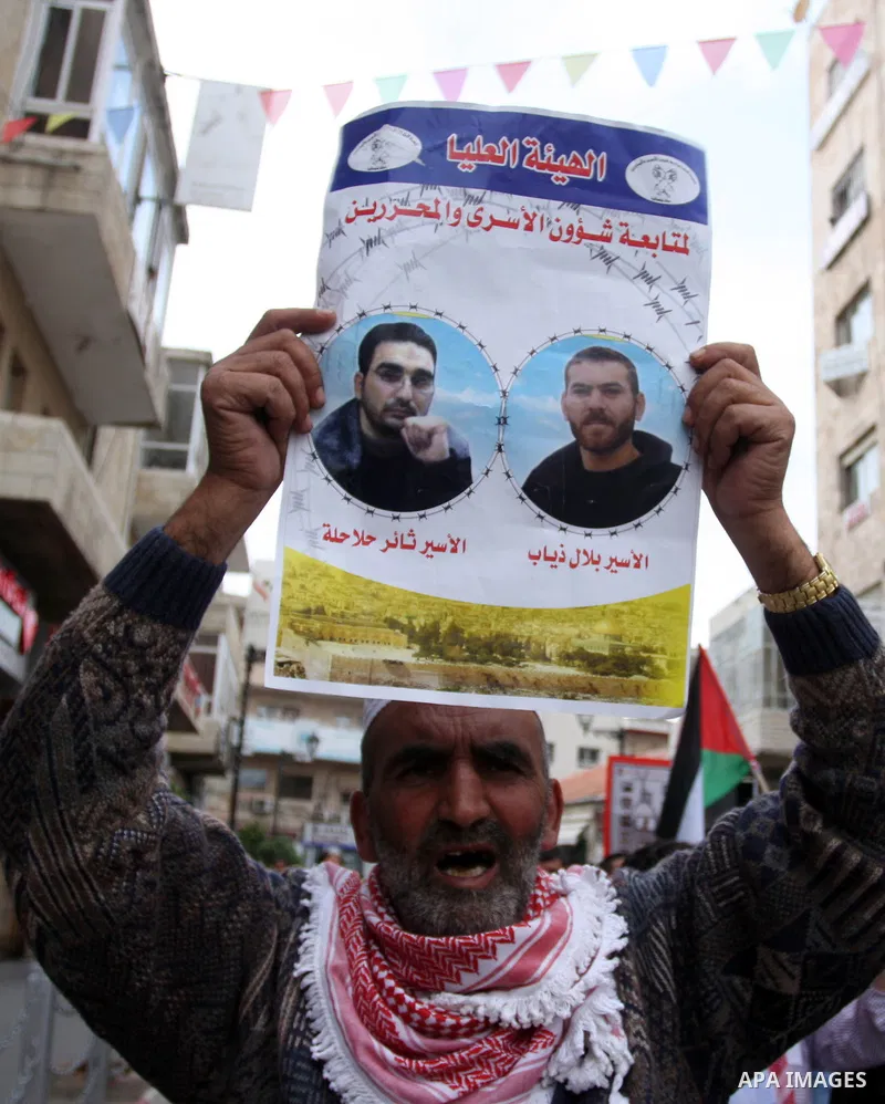 Palestinian protester holds banners and portraits of a prisoners jailed in Israel,during a rally in solidarity with prisoners in Israeli jails, in the West Bank city of Ramallah, April 30, 2012. Over the past week, over...