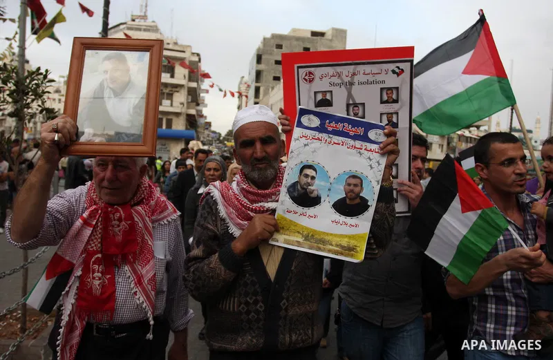 Palestinian protesters hold up banners and portraits of a prisoners jailed in Israel,during a rally in solidarity with prisoners in Israeli jails, in the West Bank city of Ramallah, April 30, 2012. Over the past week, ov...