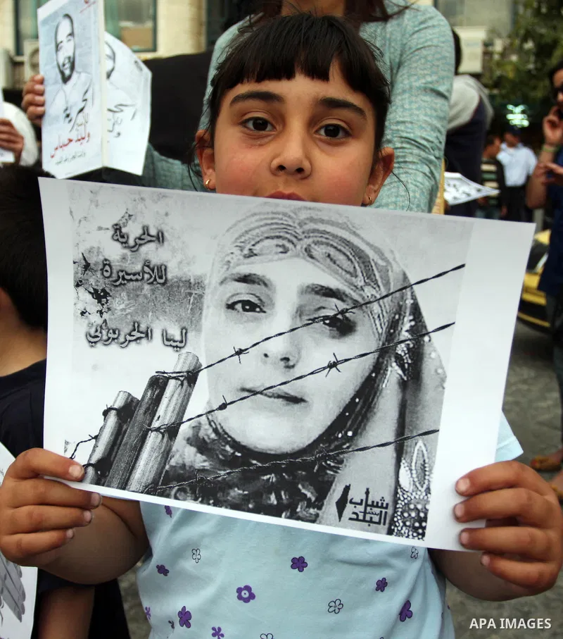 Palestinian child holds up banners and portraits of a prisoners jailed in Israel,during a rally in solidarity with prisoners in Israeli jails, in the West Bank city of Ramallah, April 30, 2012. Over the past week, over 1...