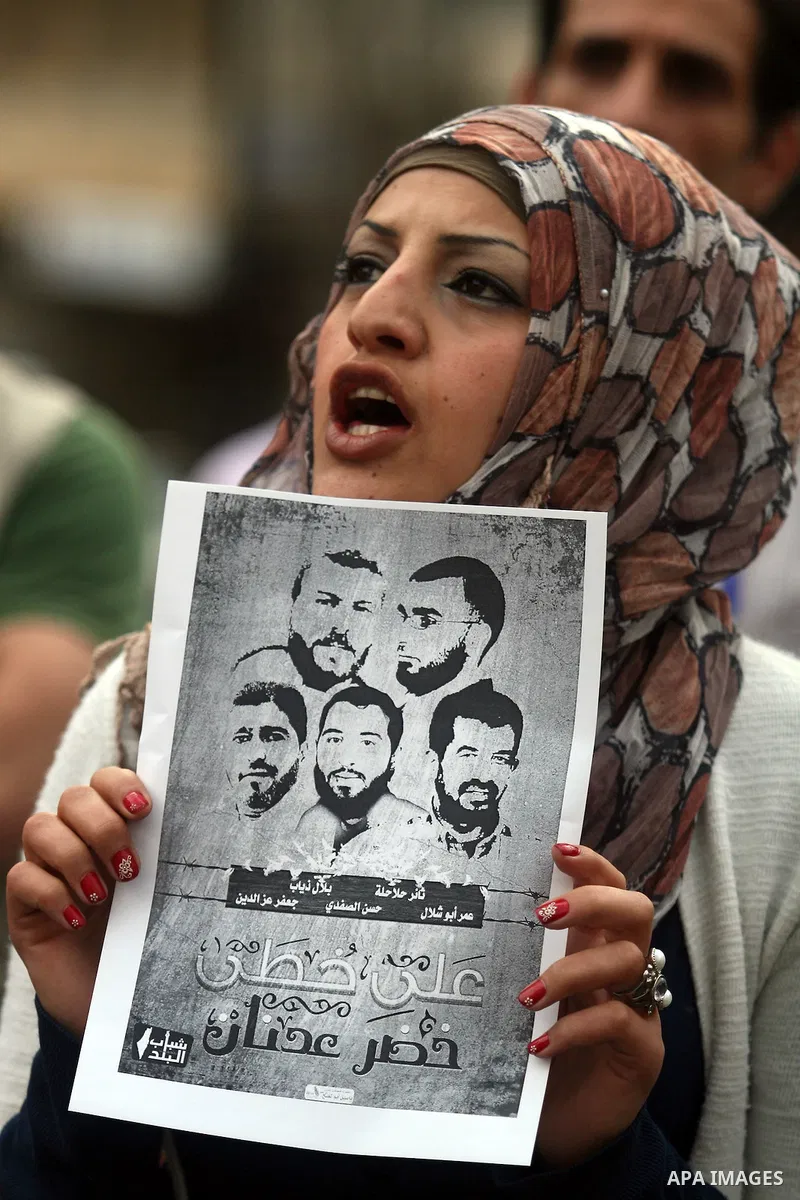 Palestinian protester holds banners and portraits of a prisoners jailed in Israel,during a rally in solidarity with prisoners in Israeli jails, in the West Bank city of Ramallah, April 30, 2012. Over the past week, over...
