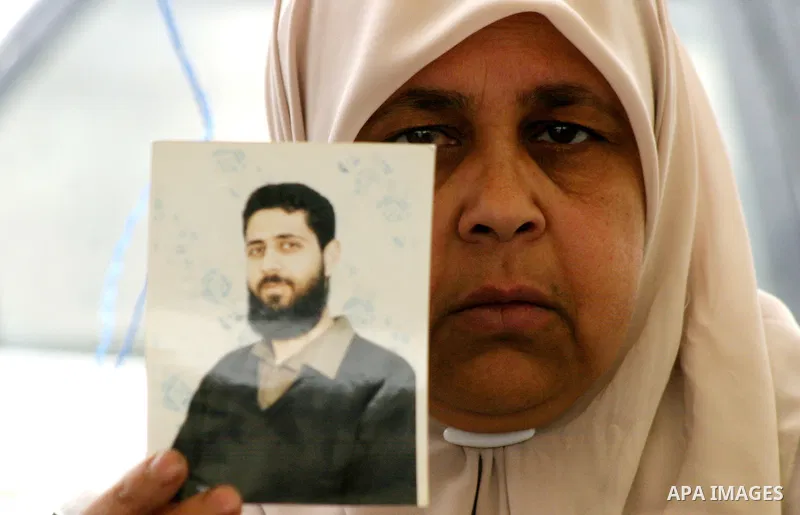Palestinian woman holds up banners and portraits of a prisoners jailed in Israel, during a Sit-in held in the neighborhood of Sheikh Jarrah, in front of the Red Cross in the West Bank city of Jerusalem, April 30, 2012. O...