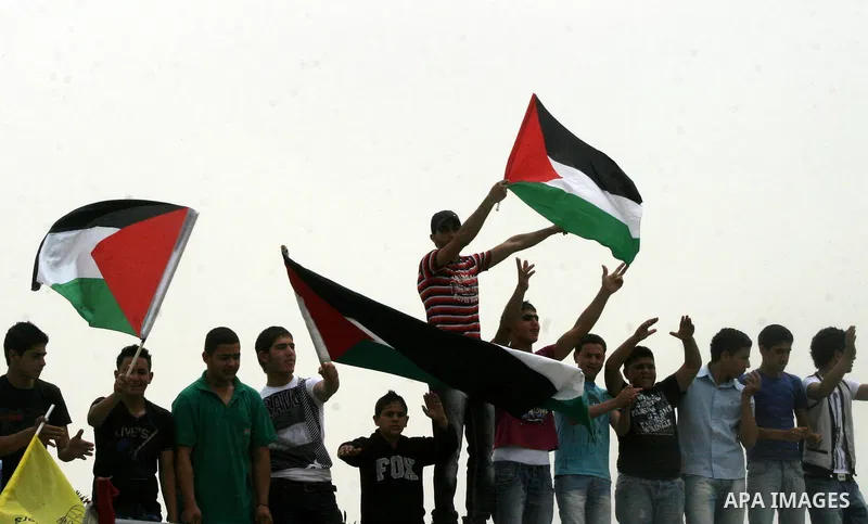 Palestinian protesters hold up banners and portraits of a prisoners jailed in Israel, during a Sit-in held in the neighborhood of Sheikh Jarrah, in front of the Red Cross in the West Bank city of Jerusalem, April 30, 201...