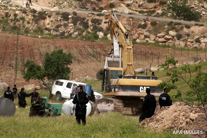 Israeli soldiers surround a bulldozer as it destroys a Palestinian farm to cows in the West Bank city of Hebron, May. 01, 2012. Reports state that tensions rose as Palestinian homes were destroyed by Israeli authorities...