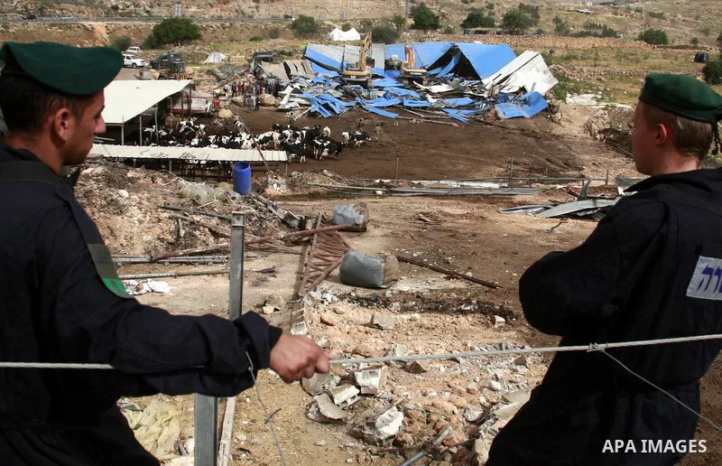 Israeli soldiers surround a bulldozer as it destroys a Palestinian farm to cows in the West Bank city of Hebron, May. 01, 2012. Reports state that tensions rose as Palestinian homes were destroyed by Israeli authorities...