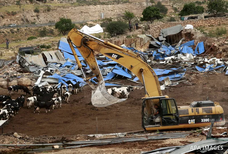 Israeli soldiers surround a bulldozer as it destroys a Palestinian farm to cows in the West Bank city of Hebron, May. 01, 2012. Reports state that tensions rose as Palestinian homes were destroyed by Israeli authorities...