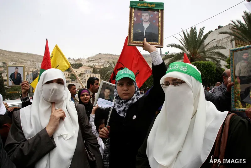 Palestinian protesters hold up banners and portraits of a prisoners jailed in Israel, during a demonstration in the West Bank city of Nablus, May 1, 2012. Over the past week, over 1,350 Palestinian prisoners have begun a...