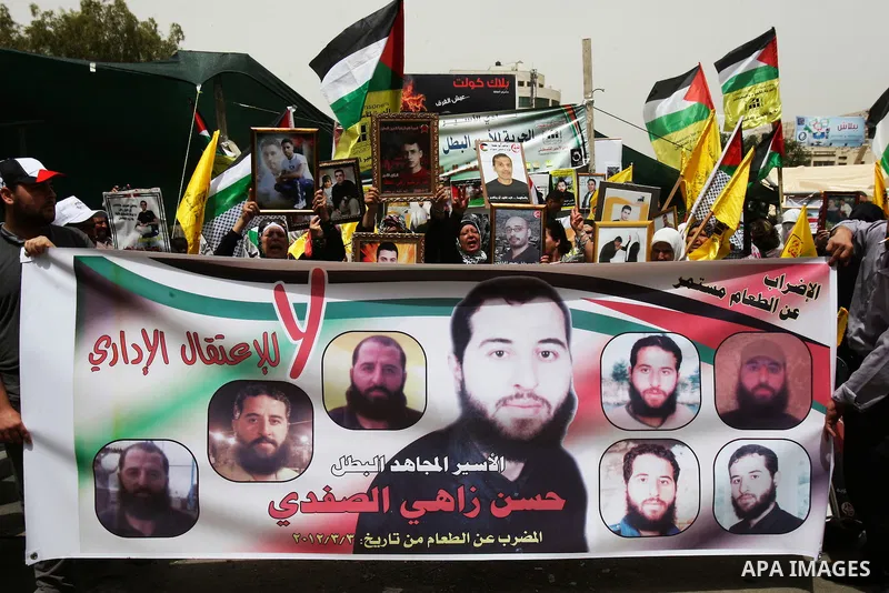 Palestinian protesters hold up banners and portraits of a prisoners jailed in Israel, during a demonstration in the West Bank city of Nablus, May 1, 2012. Over the past week, over 1,350 Palestinian prisoners have begun a...