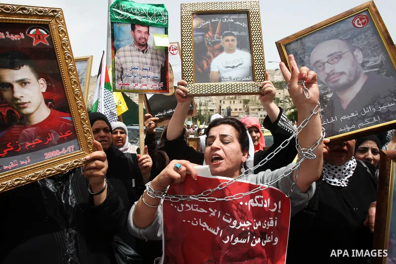 Palestinian protesters hold up banners and portraits of a prisoners jailed in Israel, during a demonstration in the West Bank city of Nablus, May 1, 2012. Over the past week, over 1,350 Palestinian prisoners have begun a...