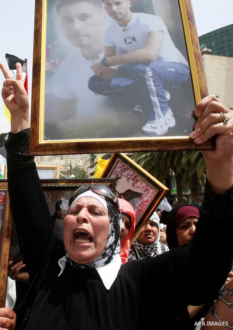Palestinian protesters hold up banners and portraits of a prisoners jailed in Israel, during a demonstration in the West Bank city of Nablus, May 1, 2012. Over the past week, over 1,350 Palestinian prisoners have begun a...