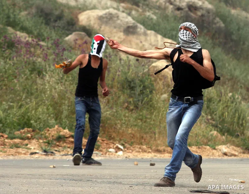 Palestinian protesters throw stones at Israeli troops during a demonstration outside Ofer military prison near the West Bank city of Ramallah on May 1, 2012 in a show of support for prisoners held in Israeli jails. Clash...