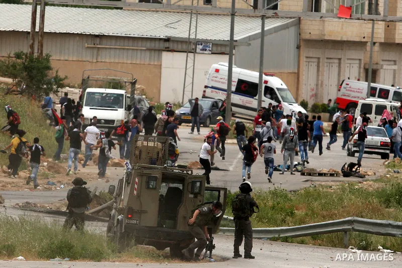 Palestinian protesters throw stones at Israeli troops during a demonstration outside Ofer military prison near the West Bank city of Ramallah on May 1, 2012 in a show of support for prisoners held in Israeli jails. Clash...