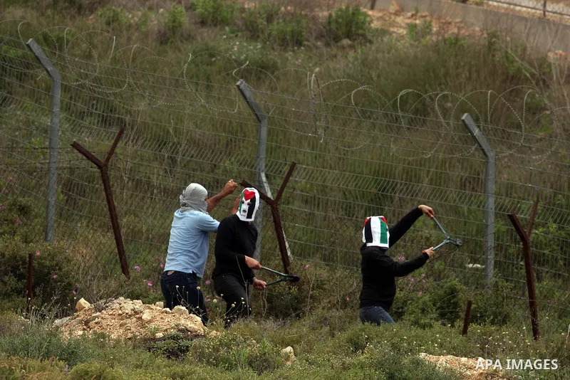 Palestinian protesters throw stones at Israeli troops during a demonstration outside Ofer military prison near the West Bank city of Ramallah on May 1, 2012 in a show of support for prisoners held in Israeli jails. Clash...