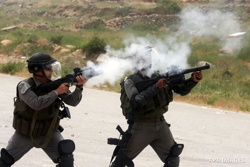 An Israeli soldiers fire tear gas towards Palestinian protesters as some 300 people gathered outside Ofer military prison near the West Bank city of Ramallah on May 1, 2012 in a show of support for prisoners held in Isra...