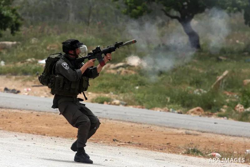 An Israeli soldier fires tear gas towards Palestinian protesters as some 300 people gathered outside Ofer military prison near the West Bank city of Ramallah on May 1, 2012 in a show of support for prisoners held in Isra...