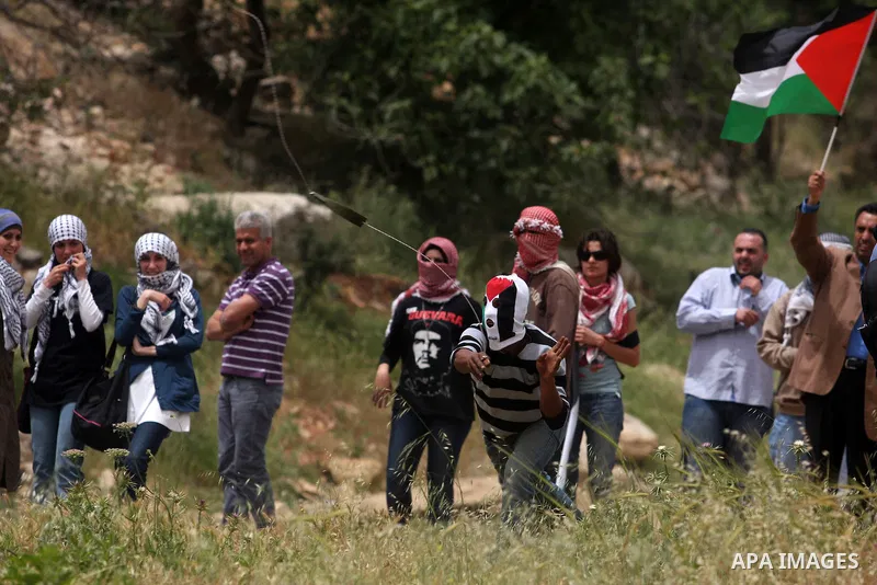 Palestinian protesters throw stones at Israeli troops during a demonstration outside Ofer military prison near the West Bank city of Ramallah on May 1, 2012 in a show of support for prisoners held in Israeli jails. Clash...