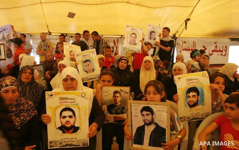 Palestinian protesters hold up banners and portraits of a prisoners jailed in Israel, during a Sit-in held in the West Bank city of Jerusalem, May 01, 2012. Over the past week, over 1,350 Palestinian prisoners have begun...
