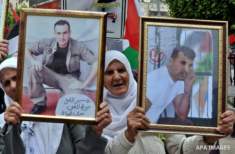 Palestinian protesters hold up banners and portraits of a prisoners jailed in Israel, during a rally in solidarity with prisoners in Israeli jails, in the West Bank city of Nablus on May 2, 2012. Photo by Nedal Eshtayah