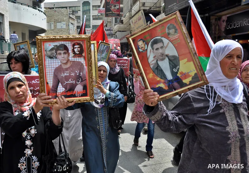 Palestinian protesters hold up banners and portraits of a prisoners jailed in Israel, during a rally in solidarity with prisoners in Israeli jails, in the West Bank city of Nablus on May 2, 2012. Photo by Nedal Eshtayah
