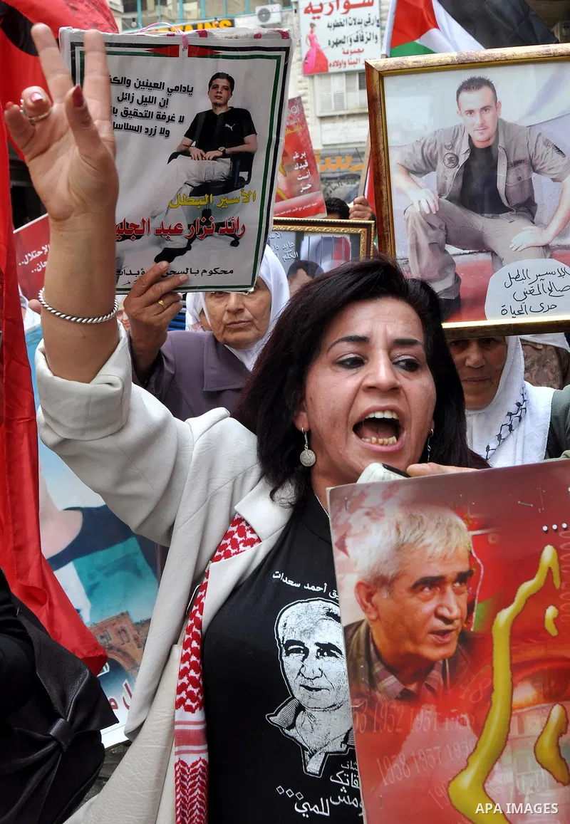 Palestinian protesters hold up banners and portraits of a prisoners jailed in Israel, during a rally in solidarity with prisoners in Israeli jails, in the West Bank city of Nablus on May 2, 2012. Photo by Nedal Eshtayah