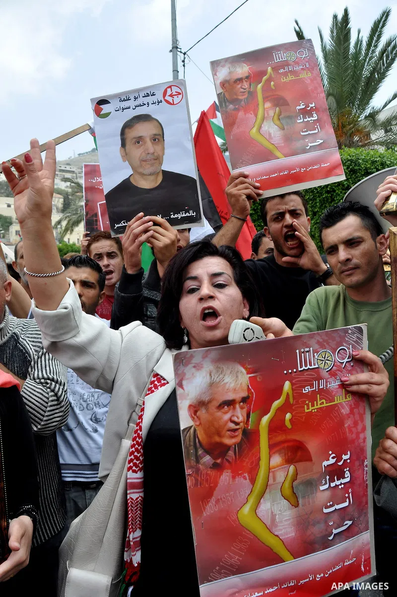 Palestinian protesters hold up banners and portraits of a prisoners jailed in Israel, during a rally in solidarity with prisoners in Israeli jails, in the West Bank city of Nablus on May 2, 2012. Photo by Nedal Eshtayah