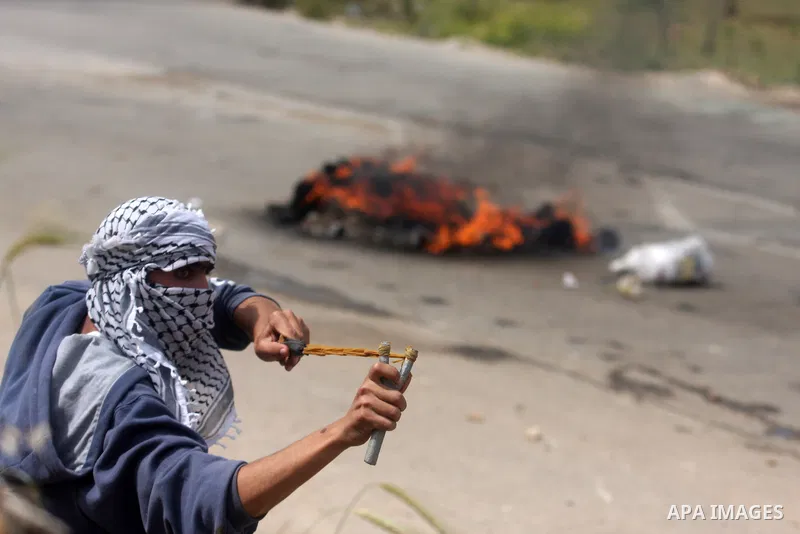 Palestinians throw stones at Israeli soldiers during clashes next to the Israeli military prison of Ofer, near Beitunia, West Bank, 02 May 2012. The protesters were protesting in solidarity with the Palestinian prisoners...