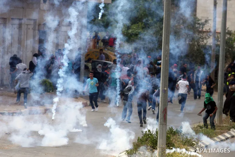 Tear gas fired by Israeli troops falls near Palestinian stone-throwers during clashes next to the Israeli military prison of Ofer, near Beitunia, West Bank, 02 May 2012. The protesters were protesting in solidarity with...