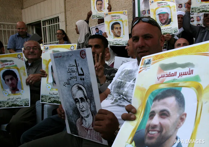 Palestinian protesters hold up banners and portraits of a prisoners jailed in Israel, during a Sit-in held outside the International Committee of the Red Cross (ICRC) in the West Bank, city of Jerusalem, May 02, 2012. Ov...