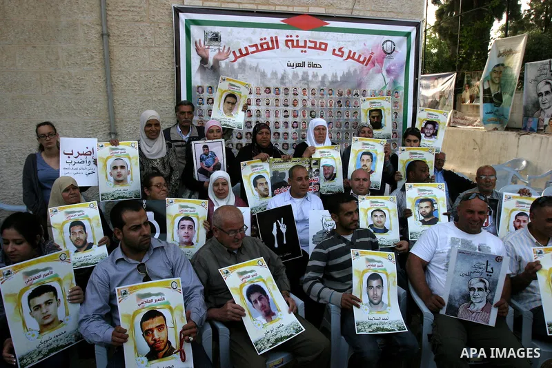 Palestinian protesters hold up banners and portraits of a prisoners jailed in Israel, during a Sit-in held outside the International Committee of the Red Cross (ICRC) in the West Bank, city of Jerusalem, May 02, 2012. Ov...