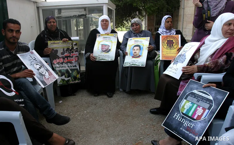 Palestinian protesters hold up banners and portraits of a prisoners jailed in Israel, during a Sit-in held outside the International Committee of the Red Cross (ICRC) in the West Bank, city of Jerusalem, May 02, 2012. Ov...