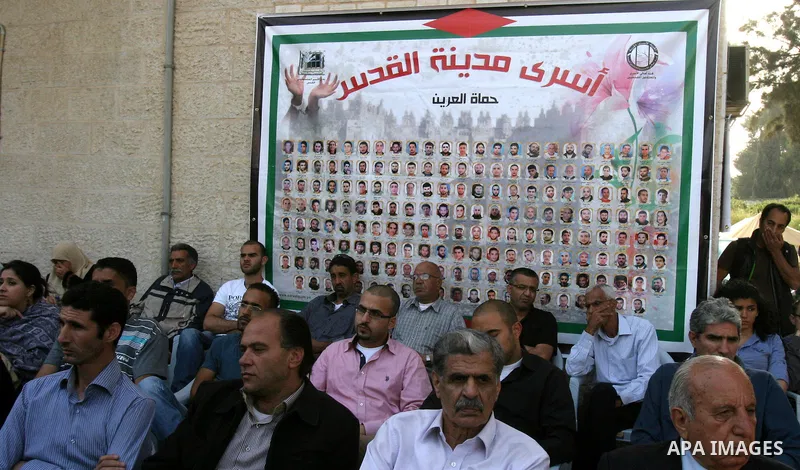 Palestinian protesters hold up banners and portraits of a prisoners jailed in Israel, during a Sit-in held outside the International Committee of the Red Cross (ICRC) in the West Bank, city of Jerusalem, May 02, 2012. Ov...